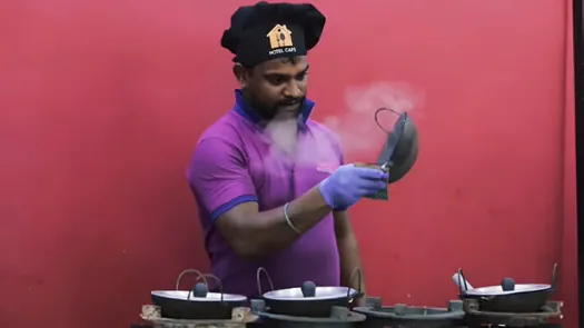 Hotel CAPS chef preparing food at a live outdoor catering station